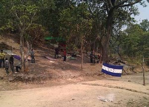 The Rio Blanco road block - a trench and a Honduran flag stretch across the road, and the communities are maintaining a constant presence in the trees to the side of the road